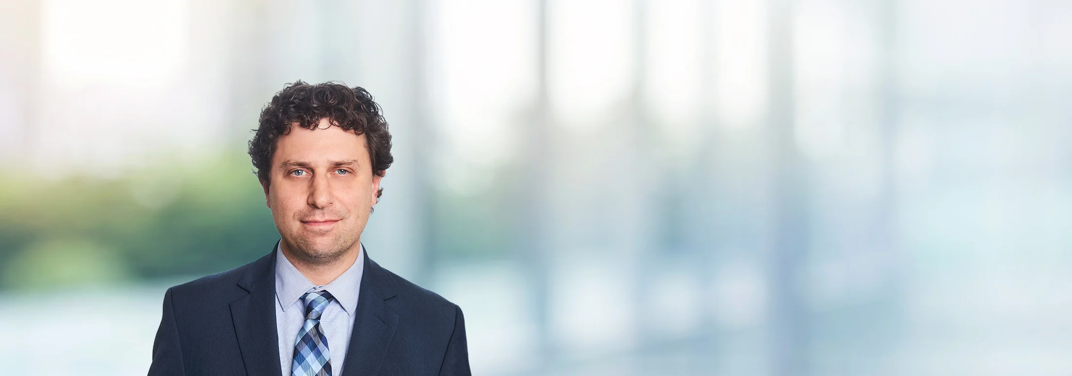 A photo of attorney Adam Yanoff against a softly blurred office background
