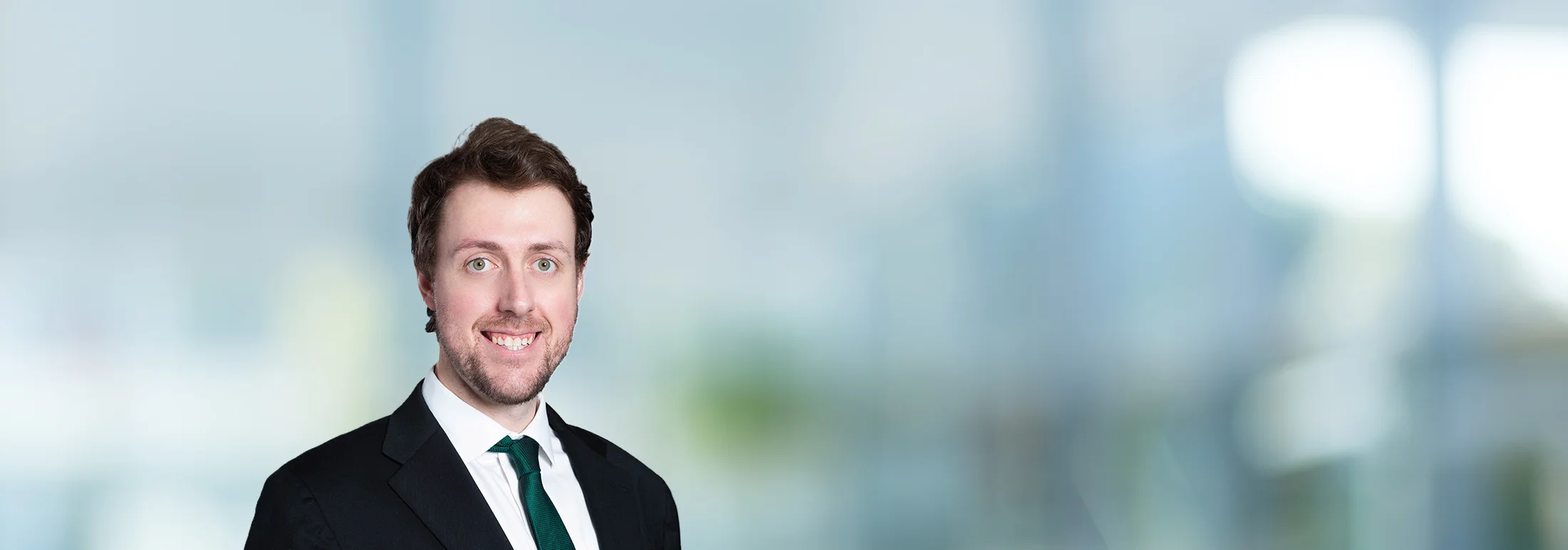 A photo of attorney Mason Englet against a softly blurred office background