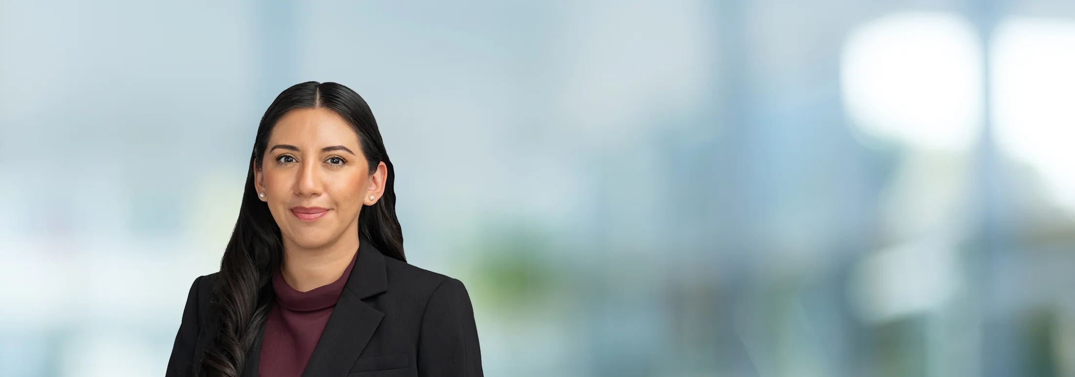 A photo of attorney Angelica Sanchez against a softly blurred office background
