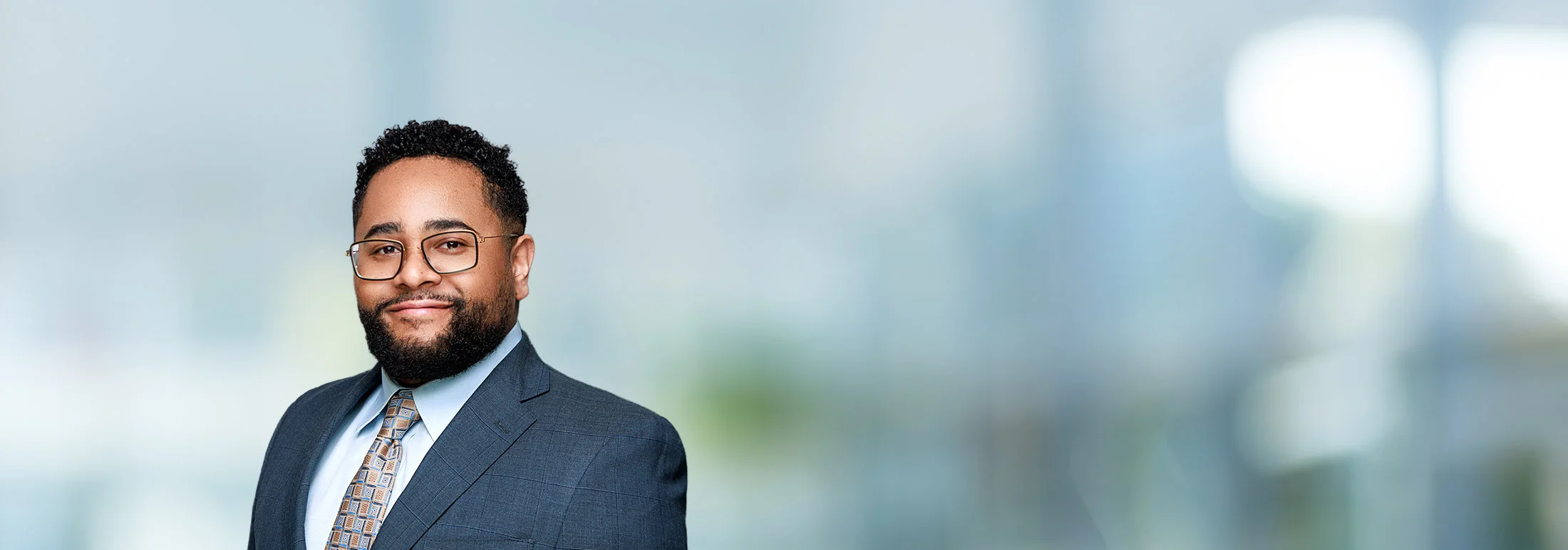 A photo of attorney Caleb Lewis against a softly blurred office background