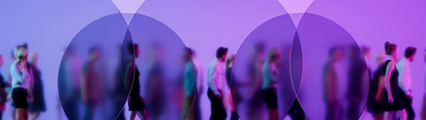 Abstract image of people walking through overlapping translucent circles in shades of purple and blue, symbolizing collaboration, connection, and a dynamic professional environment.