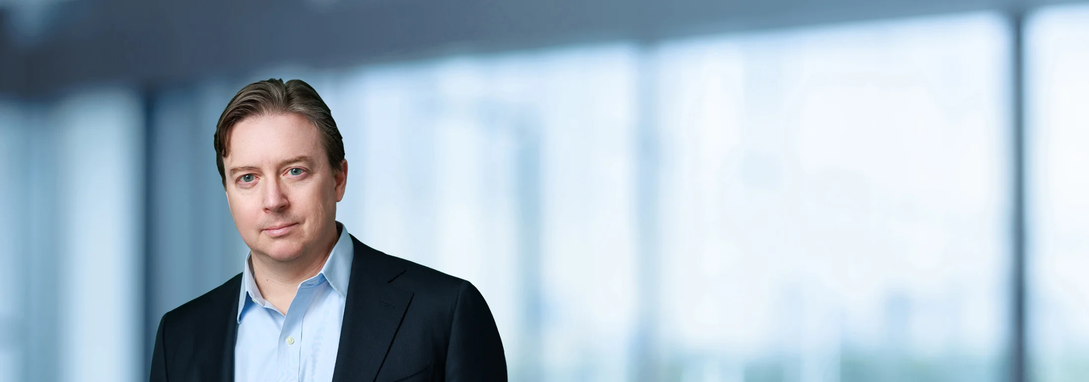 A photo of attorney, Patrick Joy, against a softly blurred office background.