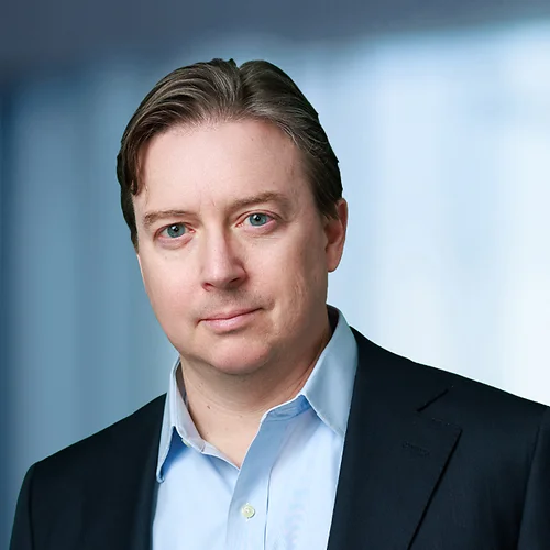 A photo of attorney, Patrick Joy, against a softly blurred office background.