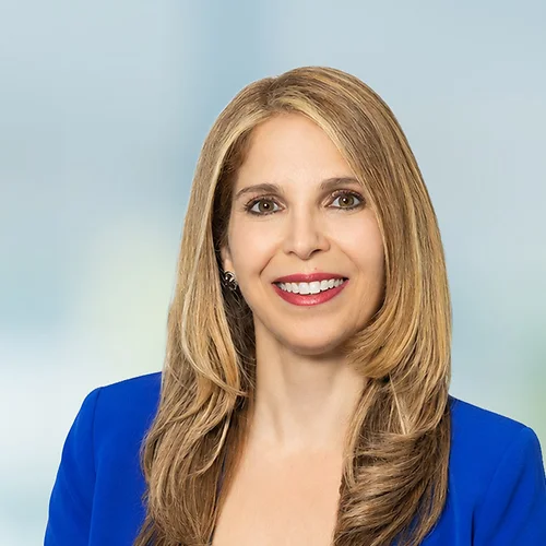 A photo of attorney Claudia Mourad against a softly blurred office background