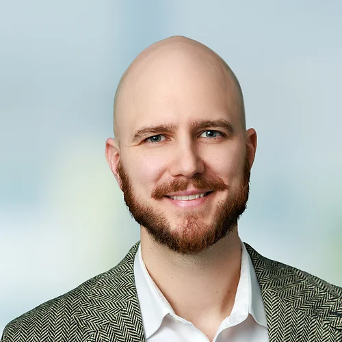 A photo of attorney, Adi Kanlic, against a softly blurred office background.