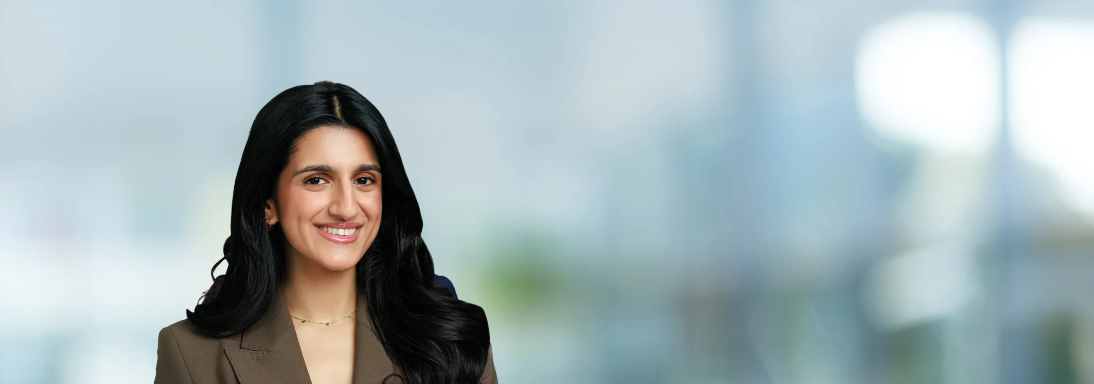 A photo of attorney, Zahrah Khan, against a softly blurred office background.
