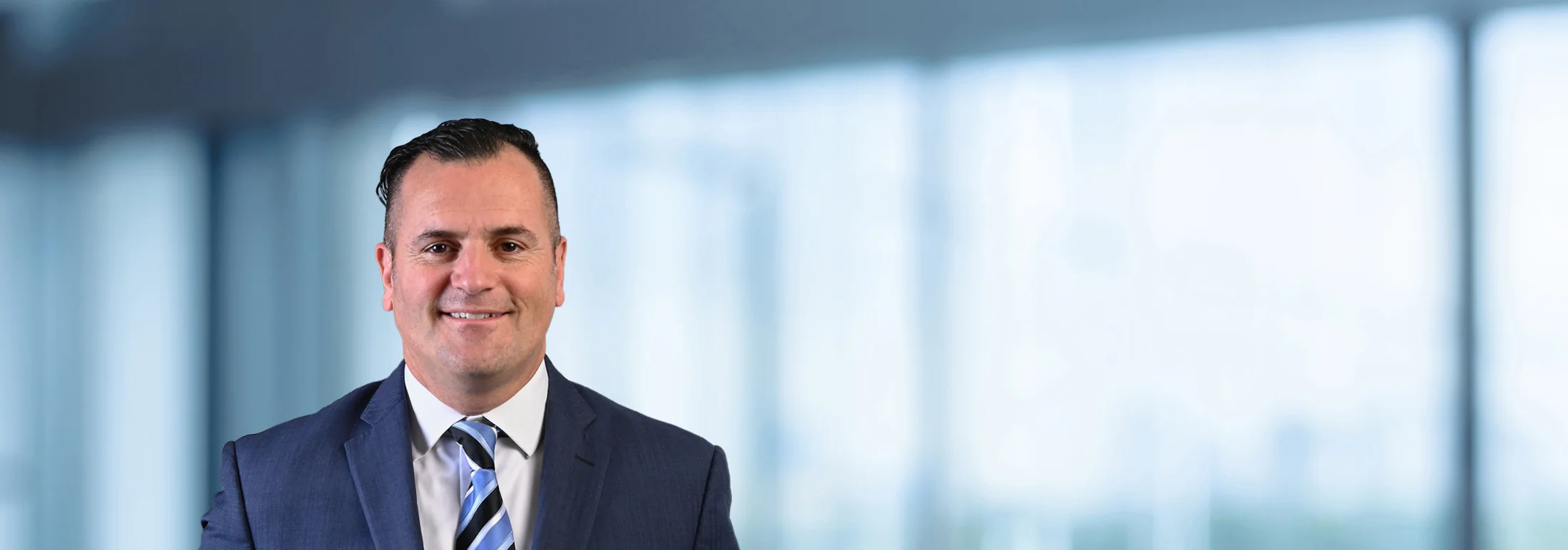 A photo of attorney, Nick Kourvetaris, against a softly blurred office background.
