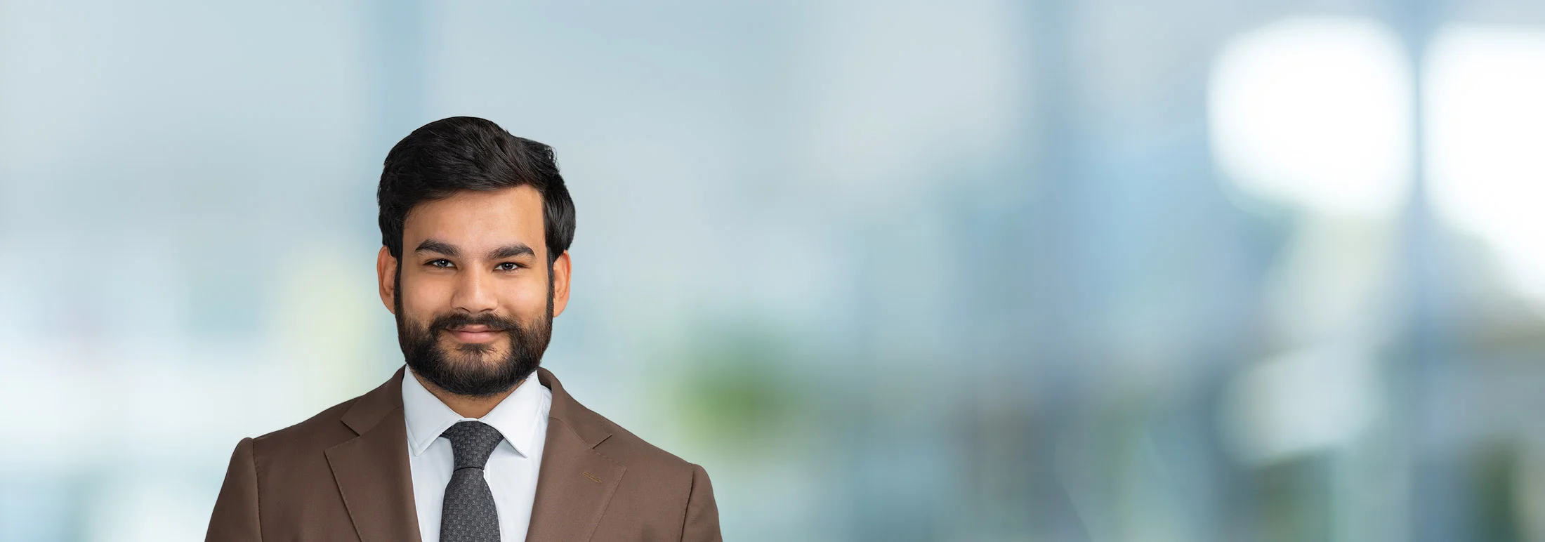 A photo of attorney Talha Muhammad against a softly blurred office background
