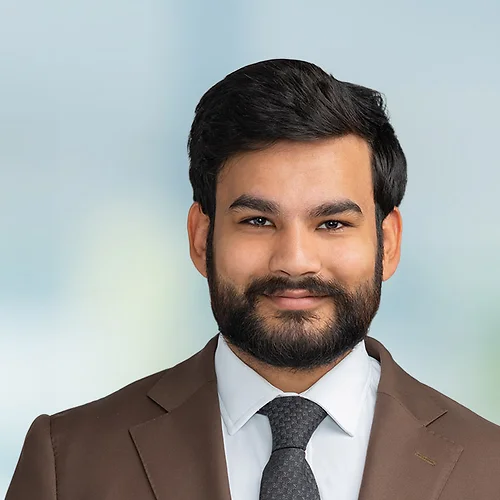 A photo of attorney Talha Muhammad against a softly blurred office background