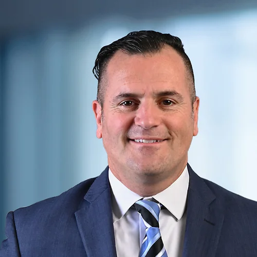 A photo of attorney, Nick Kourvetaris, against a softly blurred office background.
