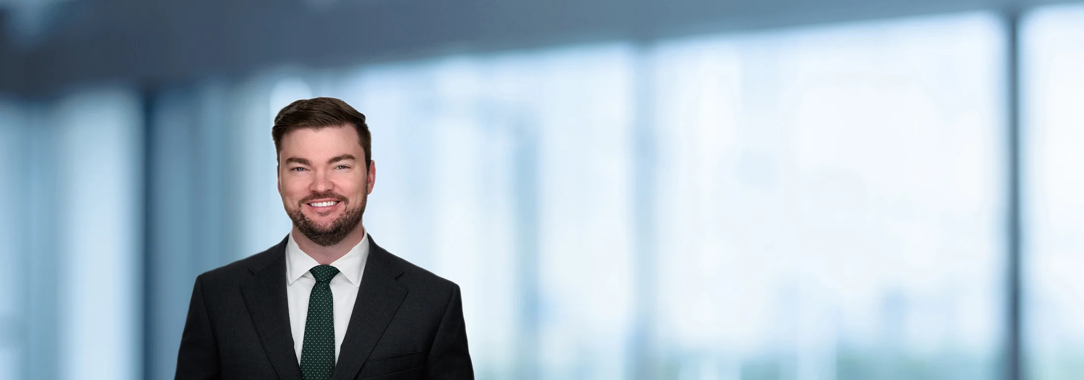 A photo of attorney Alden Butier against a softly blurred office background