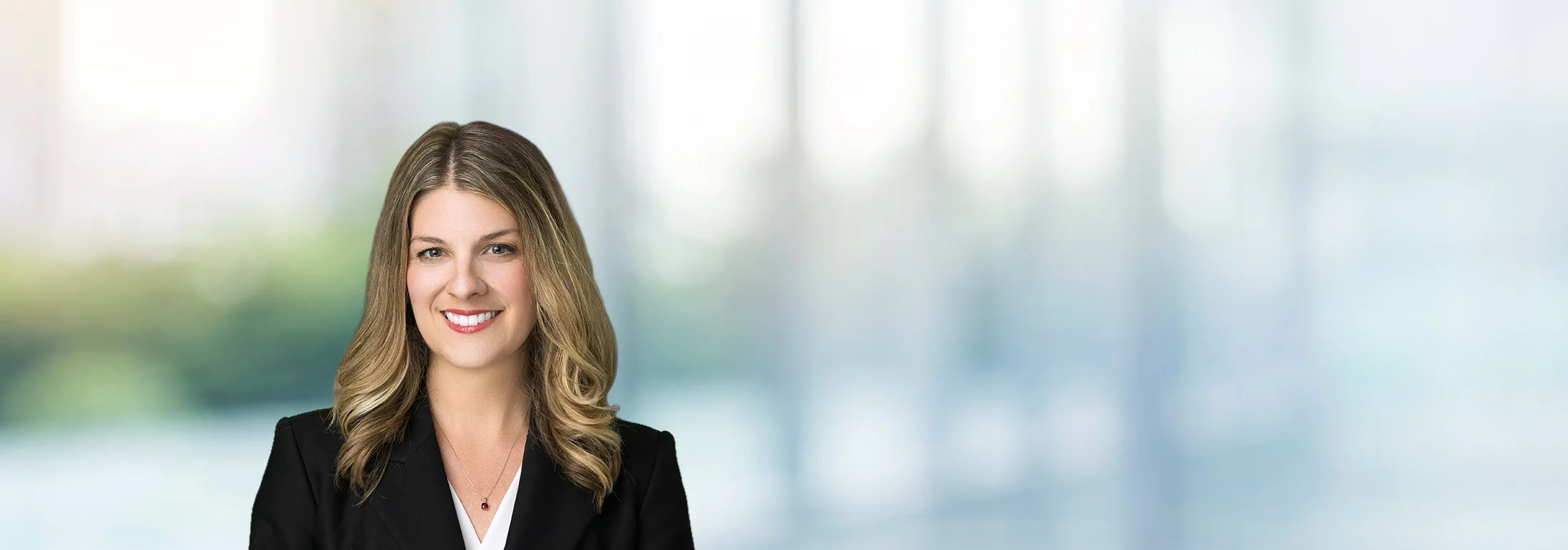 A photo of attorney, Clarissa Pintado, against a softly blurred office background.