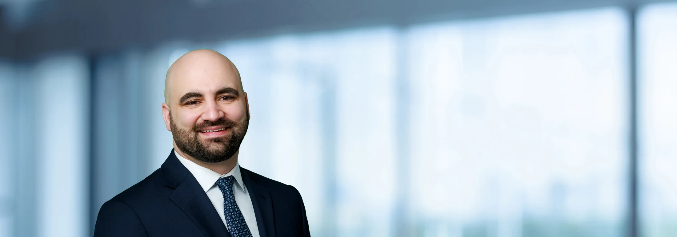 A photo of attorney, CJ Revis, against a softly blurred office background.
