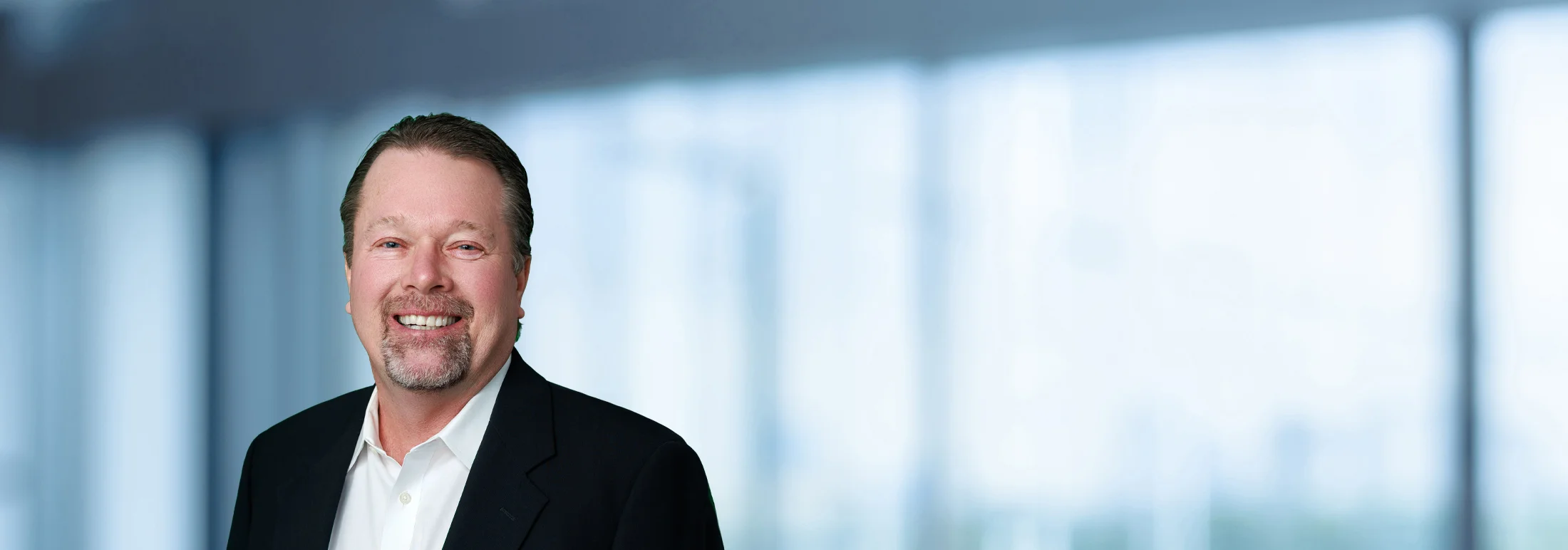 A photo of attorney, Eric Stubenvoll, against a softly blurred office background.