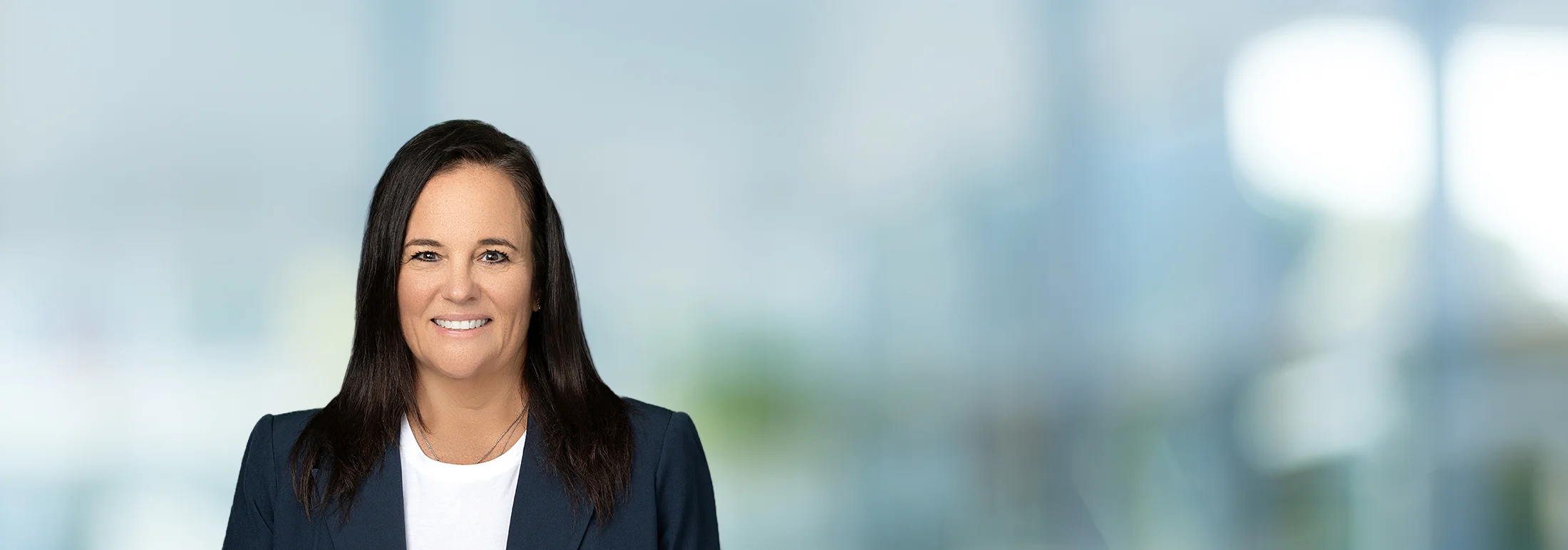 A photo of attorney, Denean Sturino, against a softly blurred office background.