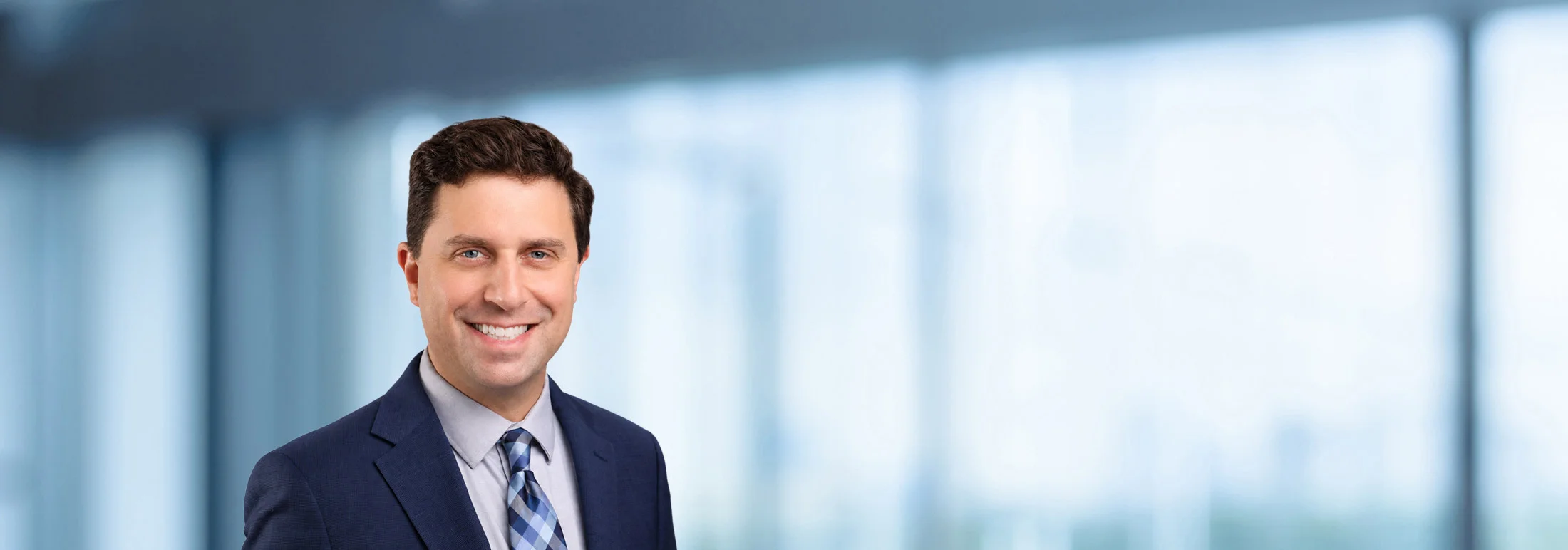 A photo of attorney Adam Yanoff against a softly blurred office background