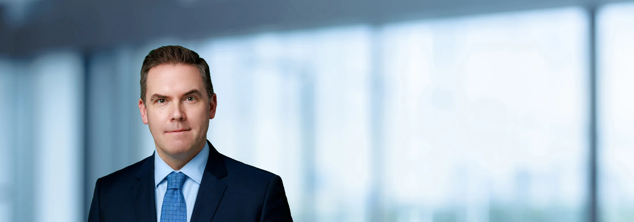 A photo of attorney, Matt Szwajkowski, against a softly blurred office background.