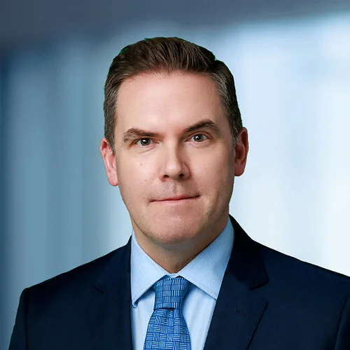 A photo of attorney, Matt Szwajkowski, against a softly blurred office background.