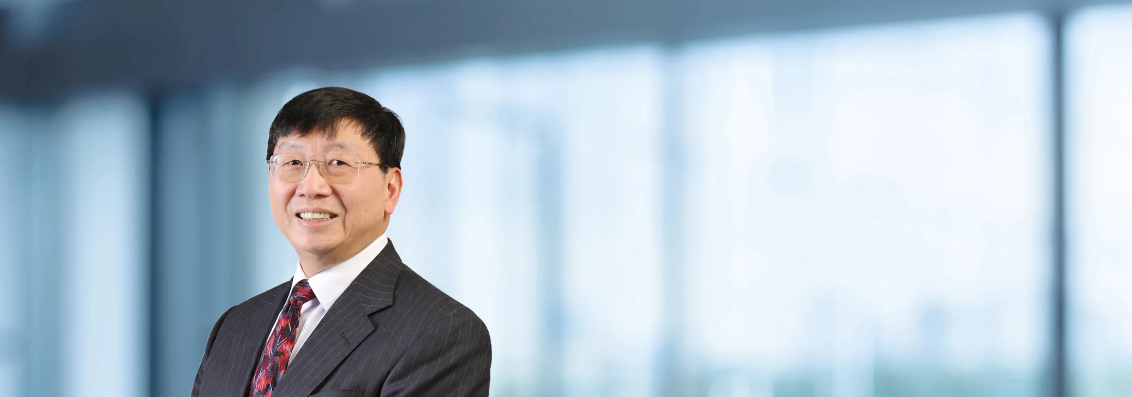 A photo of attorney, Jim Yong, against a softly blurred office background.