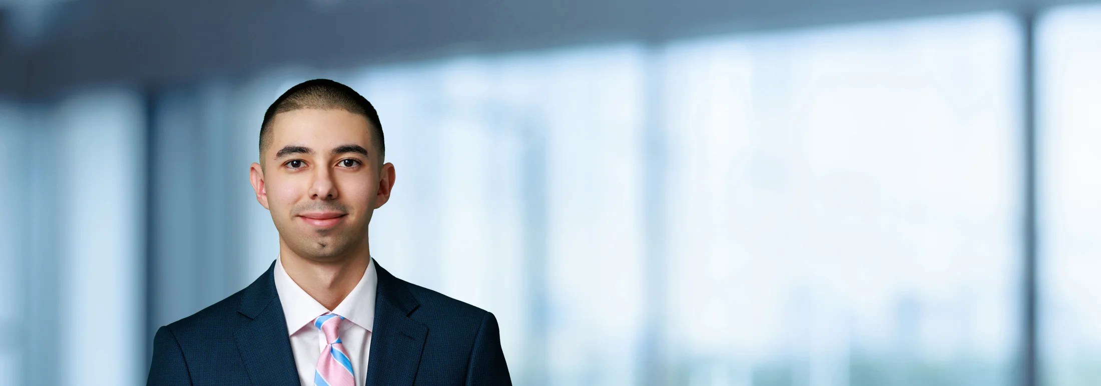 A photo of attorney, Antonio Zuniga, against a softly blurred office background.