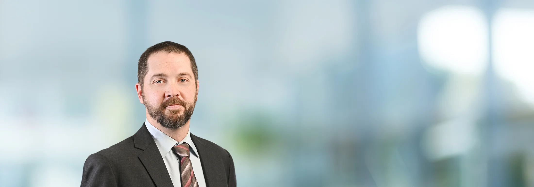 A photo of attorney, Bryan White, against a softly blurred office background.