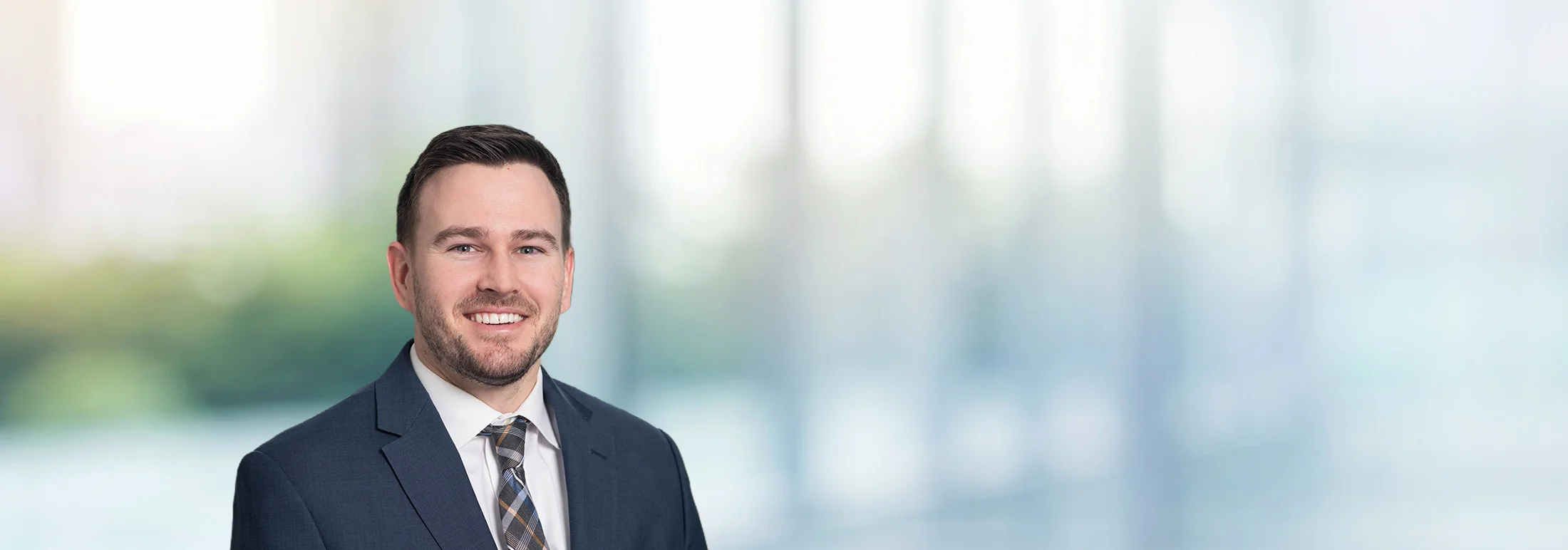 A photo of attorney, Tate Hughes, against a softly blurred office background.