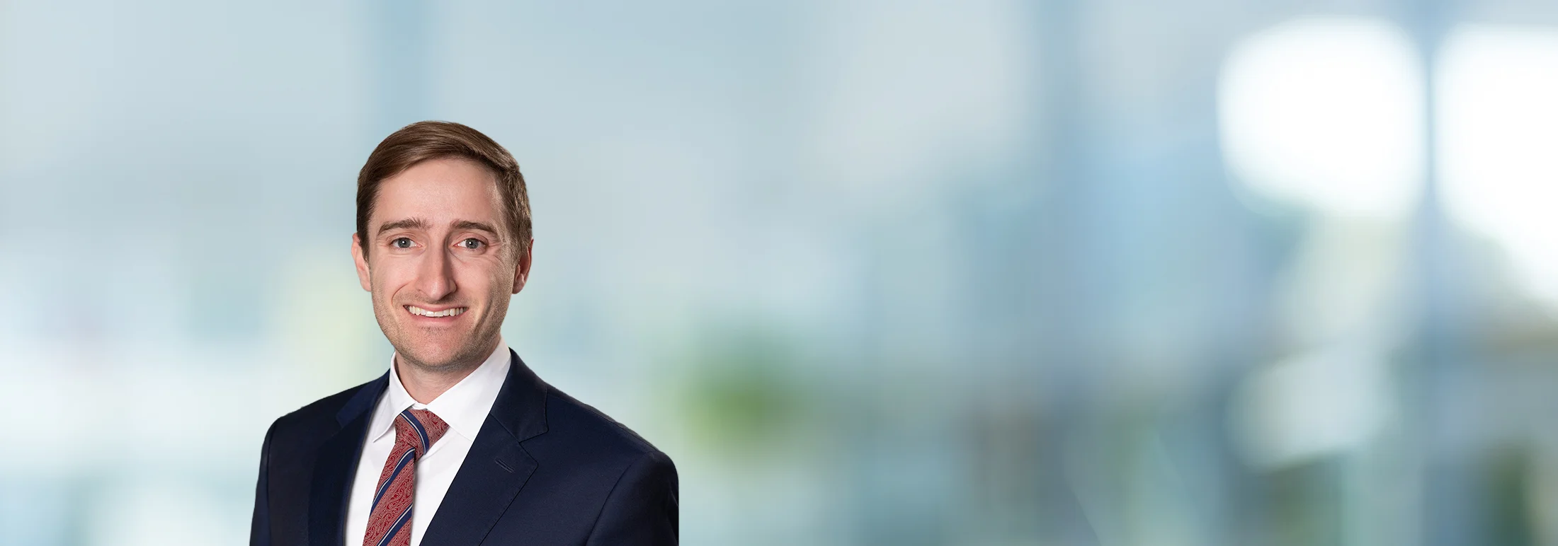 A photo of attorney, Connor Lynch, against a softly blurred office background.
