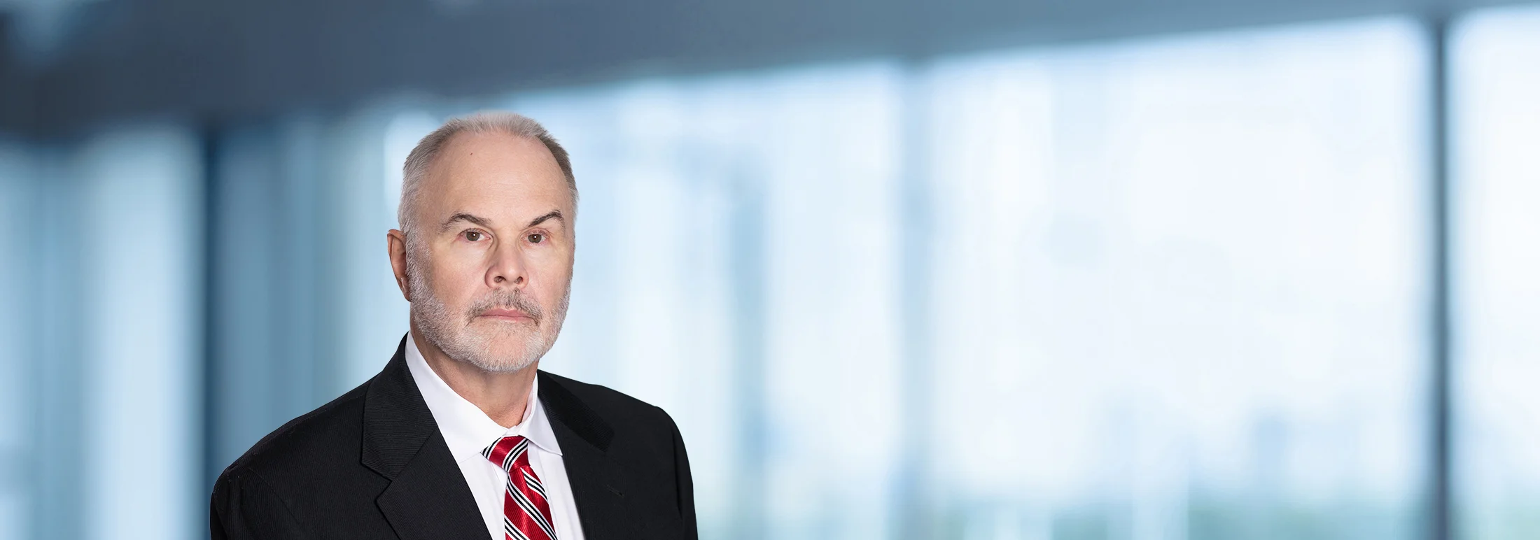 A photo of attorney, John Michels, against a softly blurred office background.