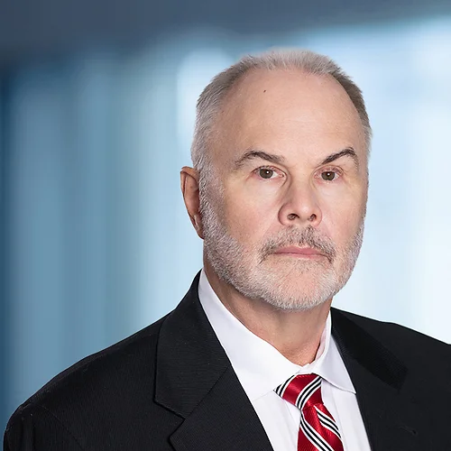 A photo of attorney, John Michels, against a softly blurred office background.