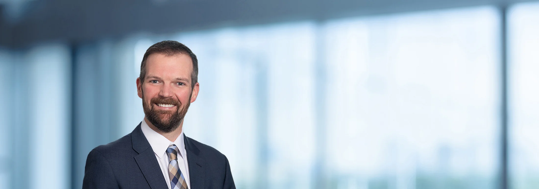 A photo of attorney, Wil Thomas, against a softly blurred office background.