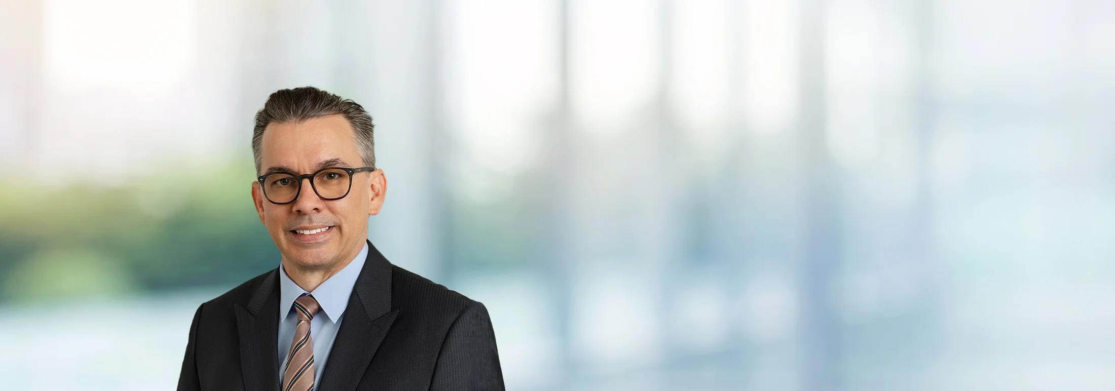 A photo of attorney, Justin Twigg, against a softly blurred office background