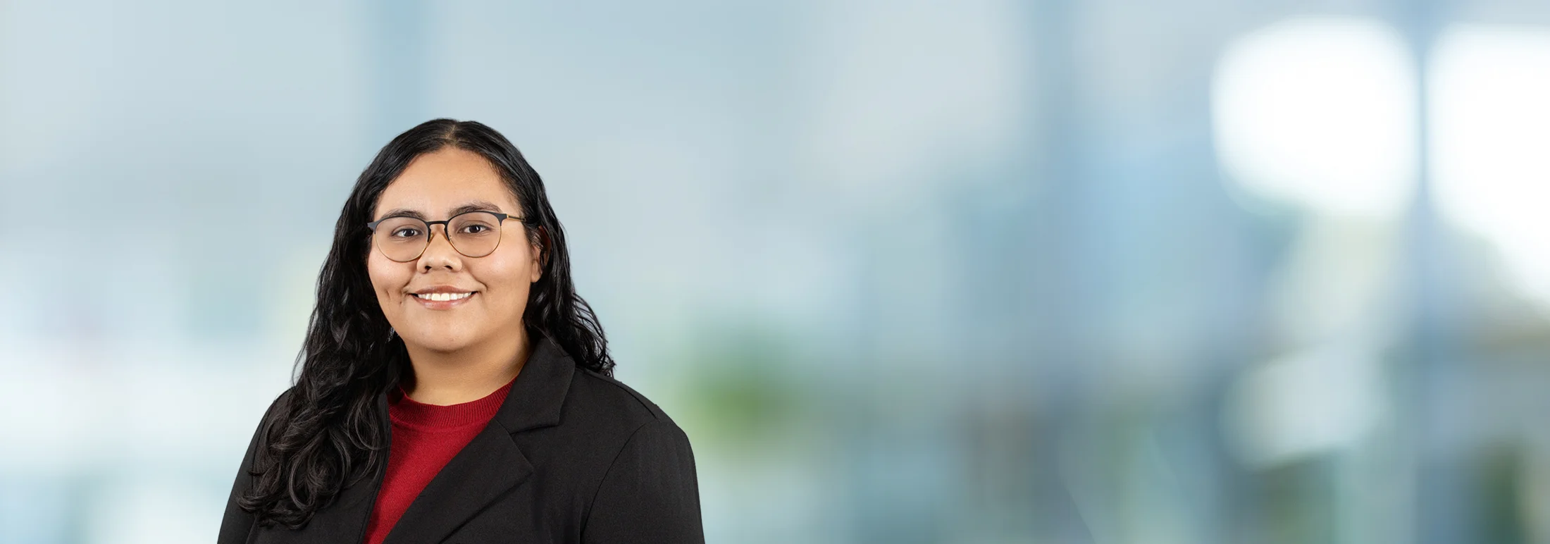 A photo of attorney, Veronica Valdez, against a softly blurred office background