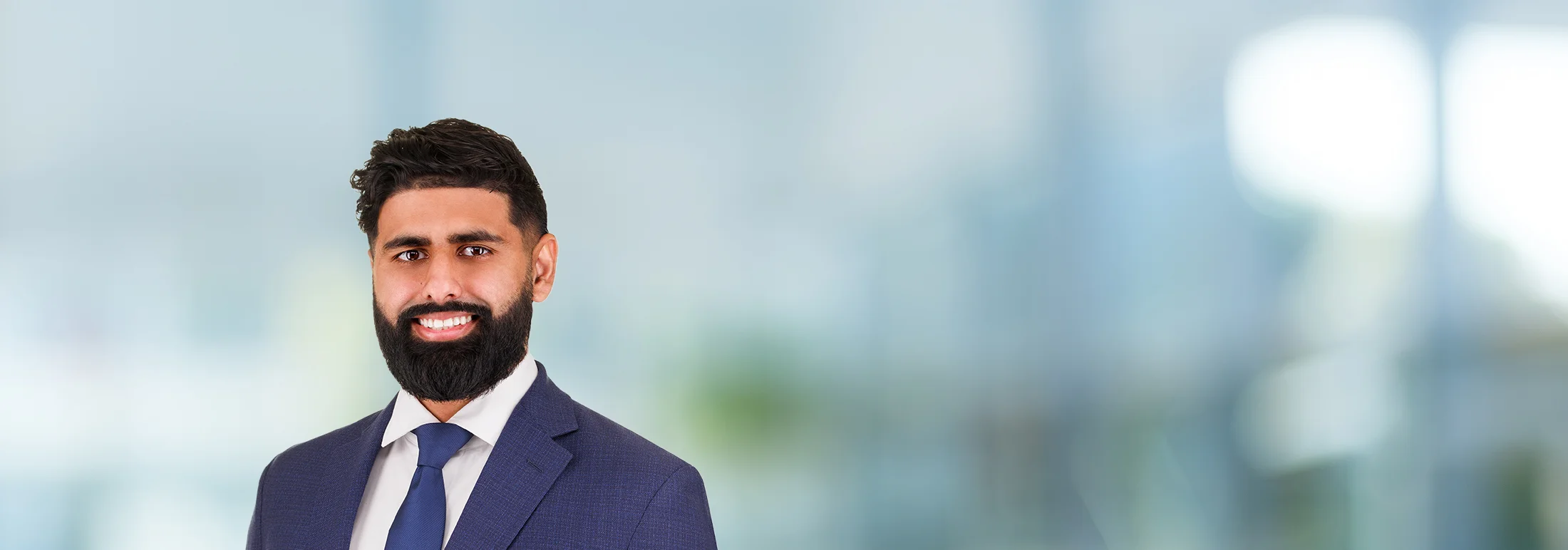 A photo of attorney, Kevin Sran, against a softly blurred office background.