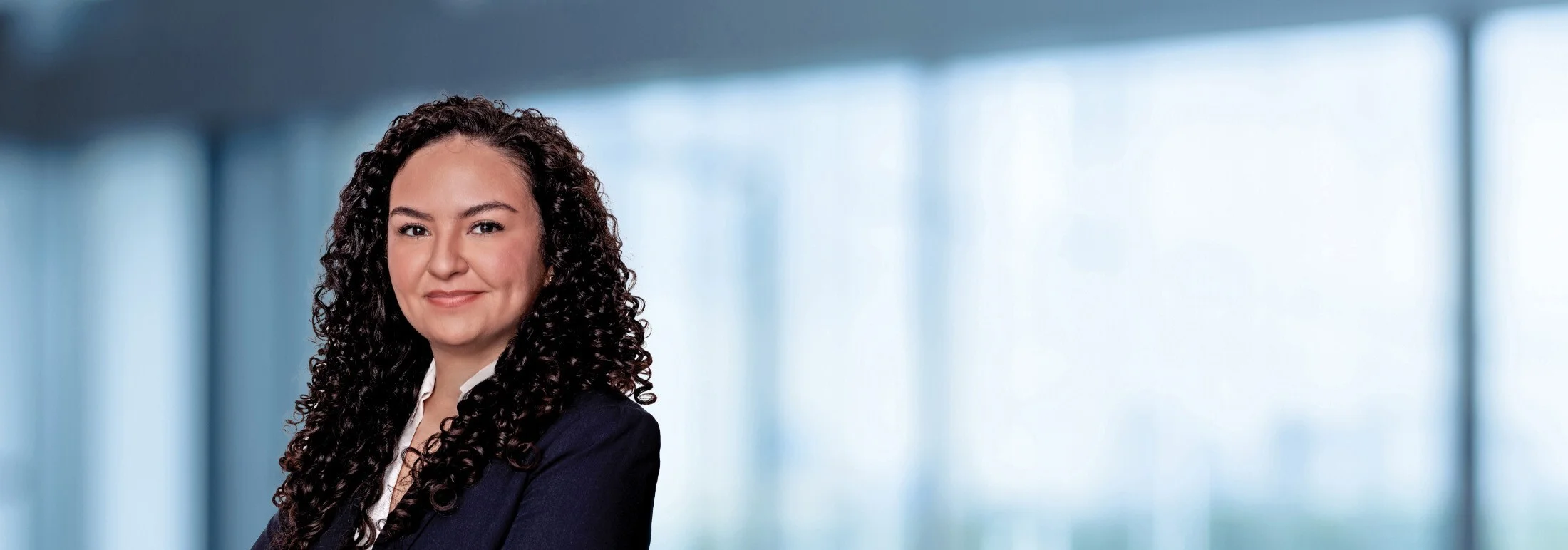 A photo of attorney, Alexis Arteaga, against a softly blurred office background