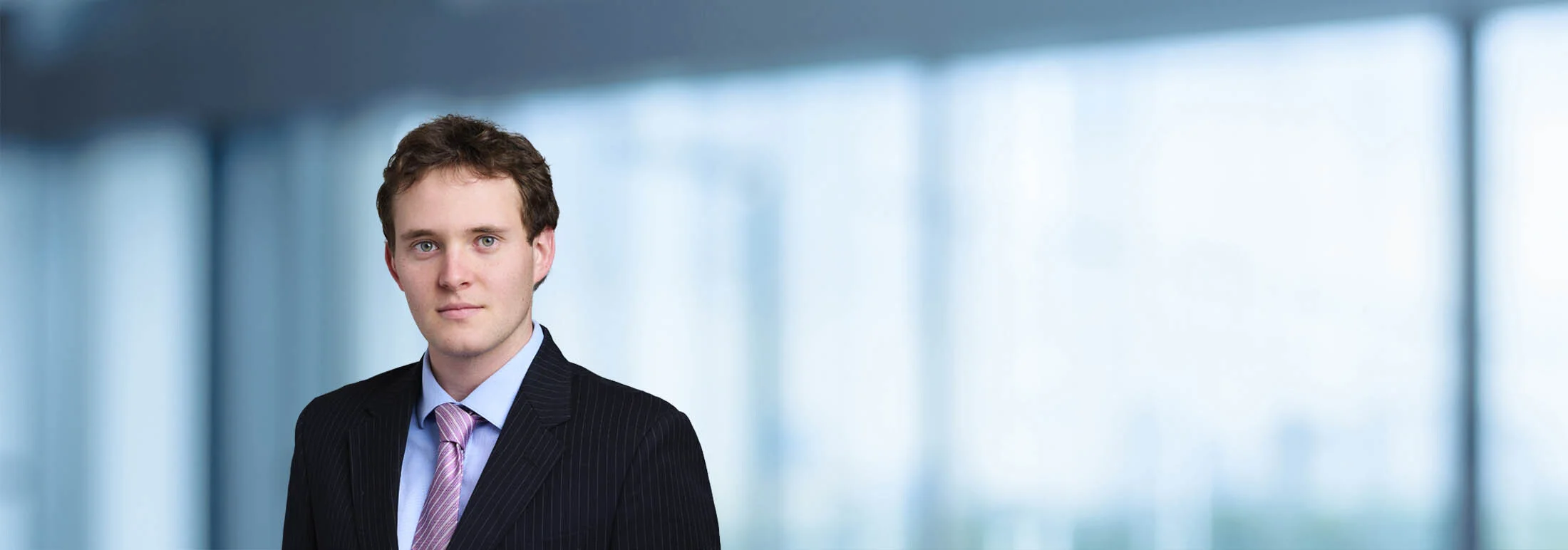A photo of attorney, Renat Sigunov, against a softly blurred office background