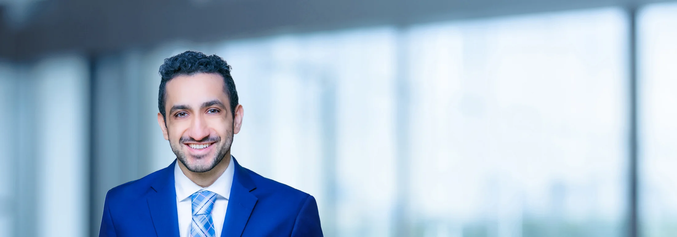 A photo of attorney, Arian Hashemi, against a softly blurred office background