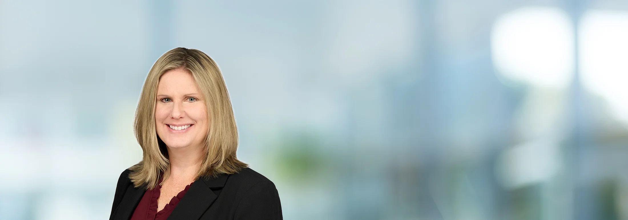A photo of attorney, Jennifer Sutton, against a softly blurred office background