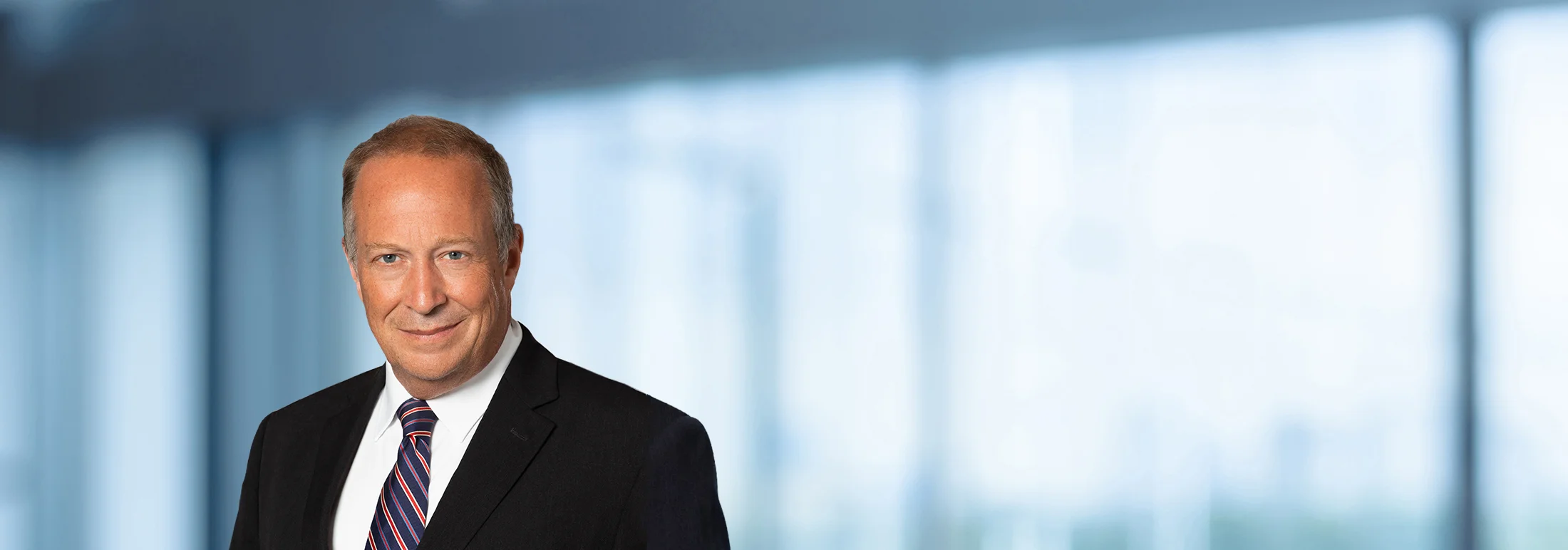 A photo of attorney, Emmett Gilman, against a softly blurred office background
