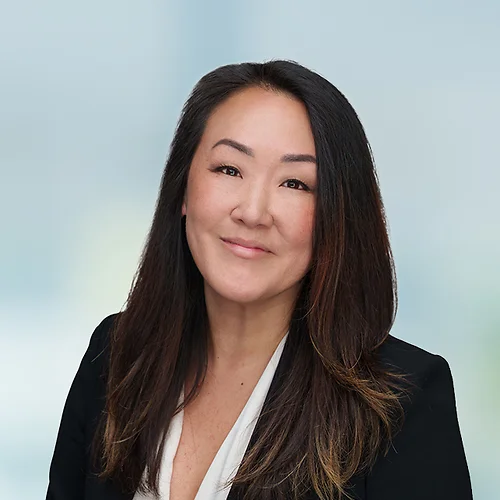 A photo of attorney, Sumy Kim, against a softly blurred office background
