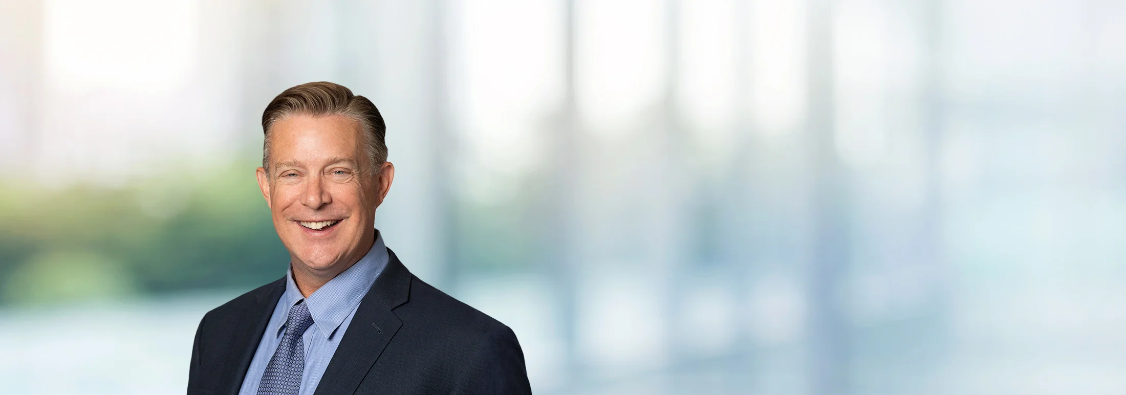 A photo of attorney, Matt Zumstein, against a softly blurred office background
