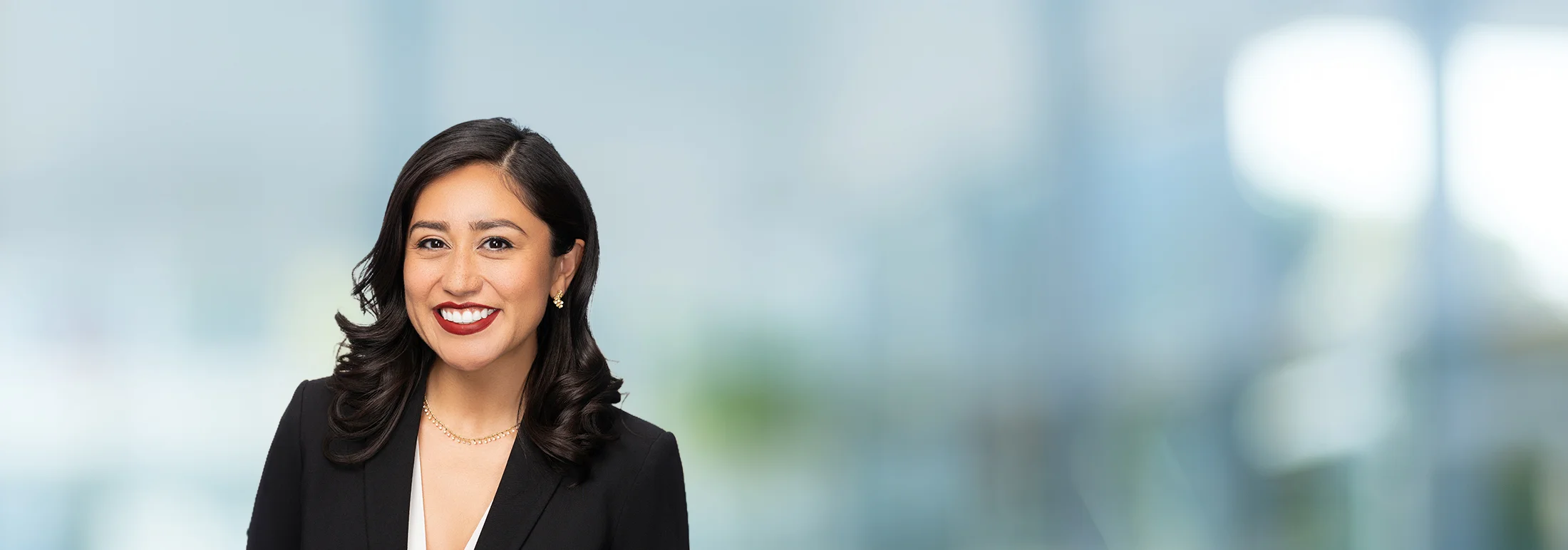 A photo of attorney Adriana Rodriguez against a softly blurred office background