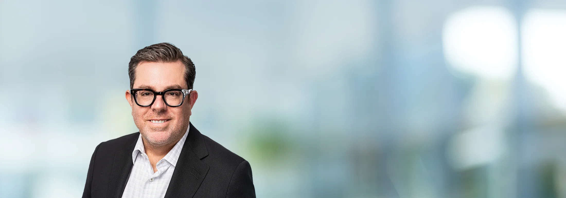 A photo of attorney Derek Sachs against a softly blurred office background