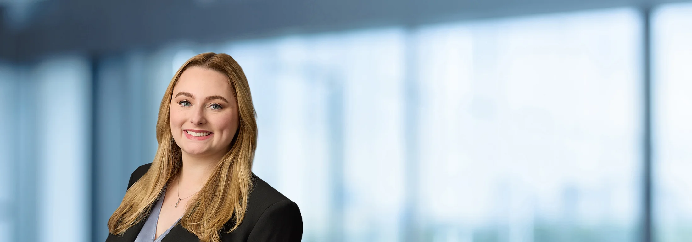 A photo of attorney Grace Zusman against a softly blurred office background