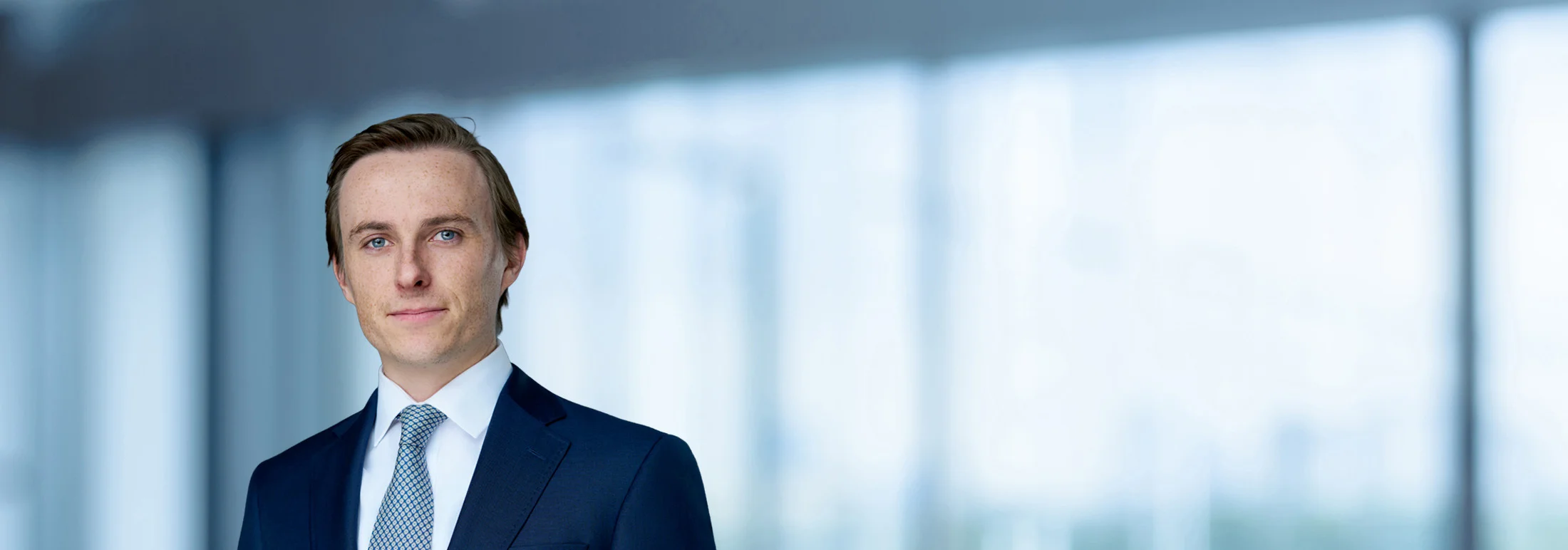 A photo of attorney Maxfield Daley-Watson against a softly blurred office background