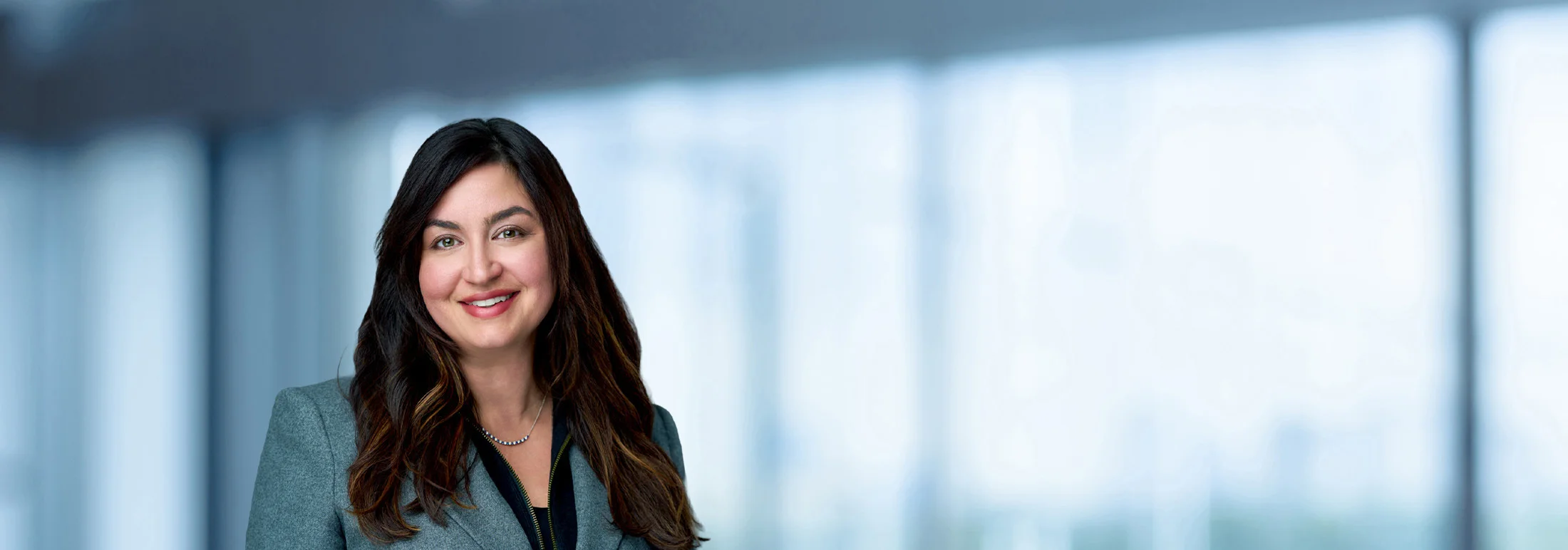 A photo of attorney, Rachael Loughlin, against a softly blurred office background