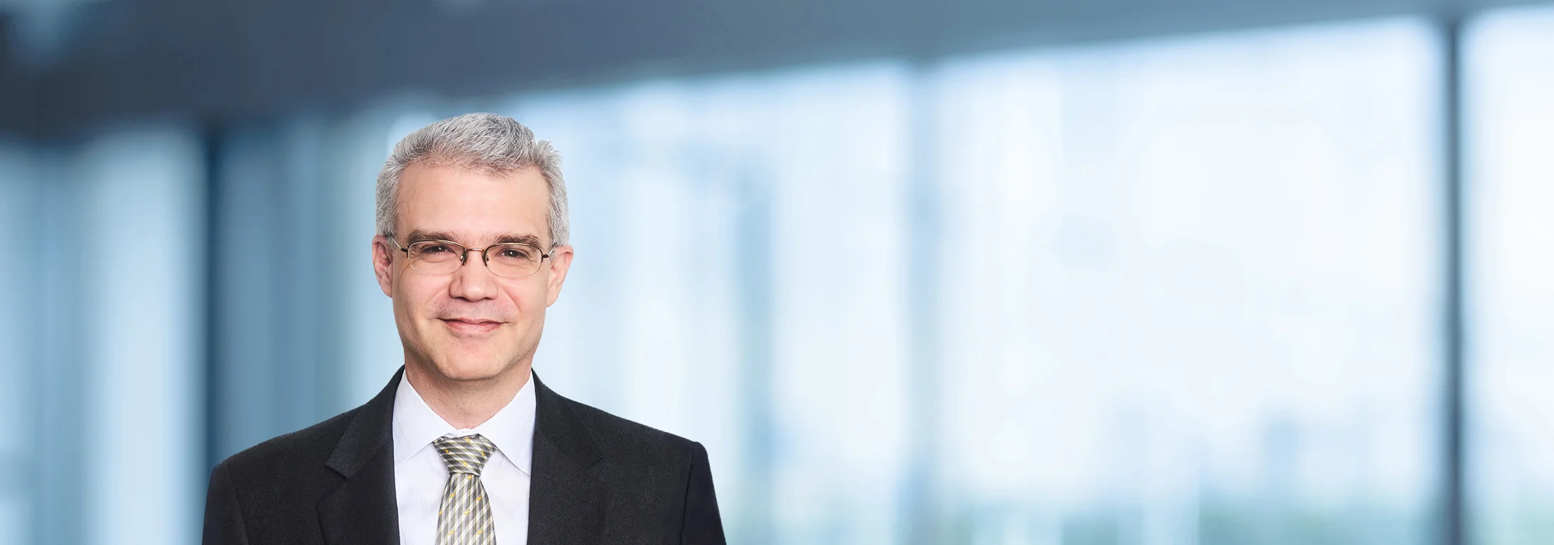 A photo of attorney Christopher Negrete against a softly blurred office background
