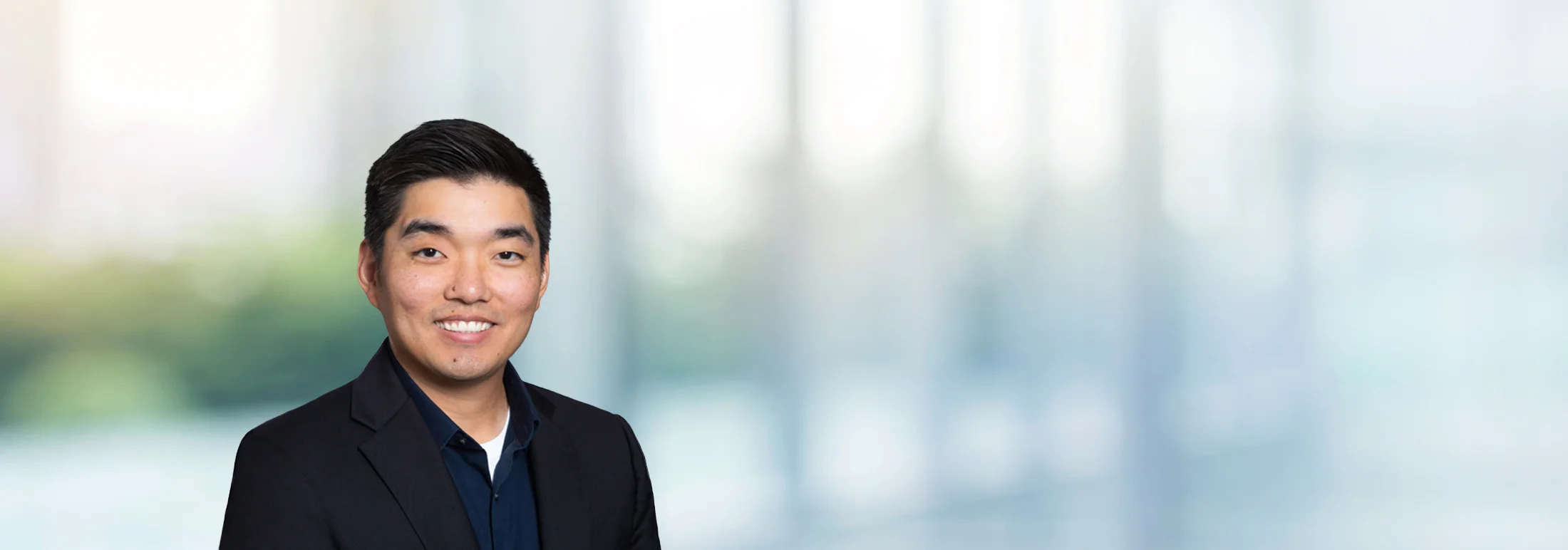 A photo of attorney Andrew Cho against a softly blurred office background