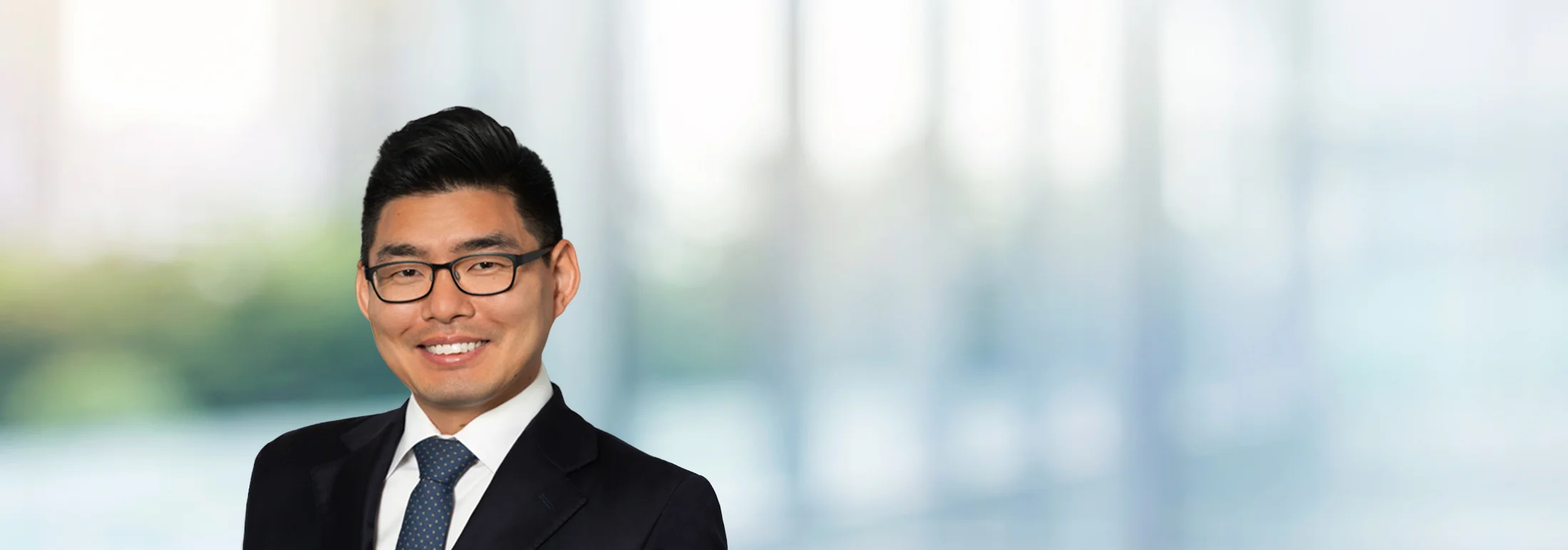 A photo of attorney, Christopher Cho, against a softly blurred office background