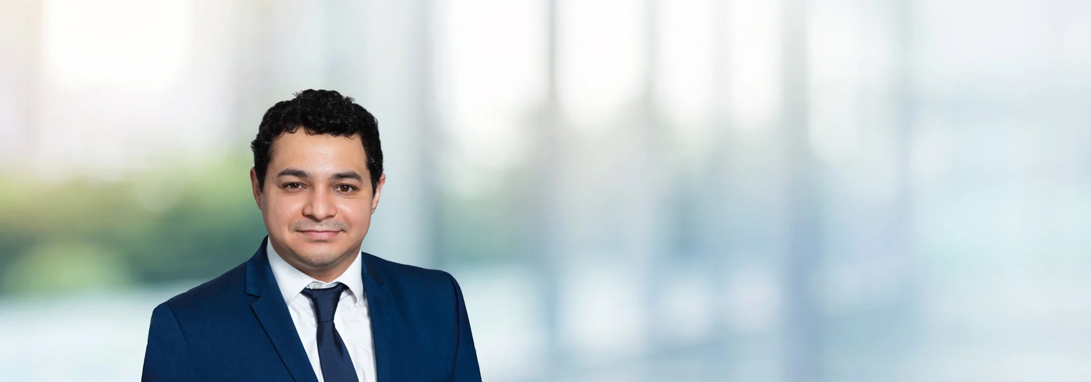 A photo of attorney Eduardo Dominguez against a softly blurred office background
