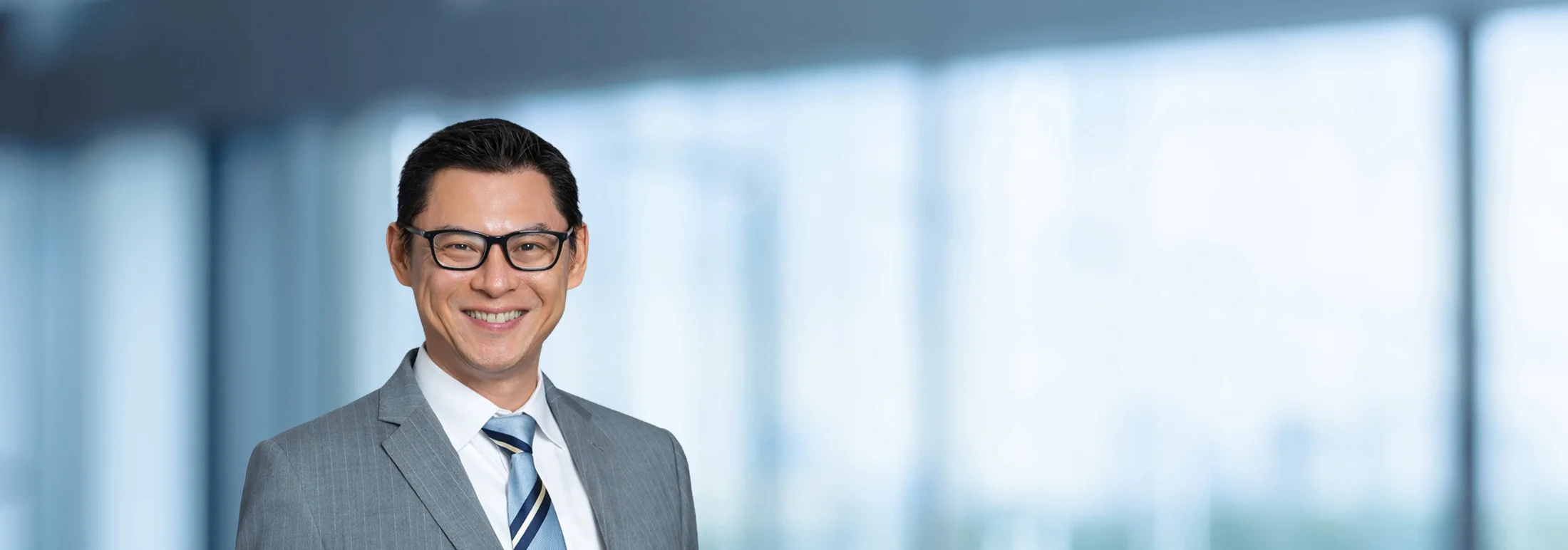 A photo of attorney Jier Dong against a softly blurred office background